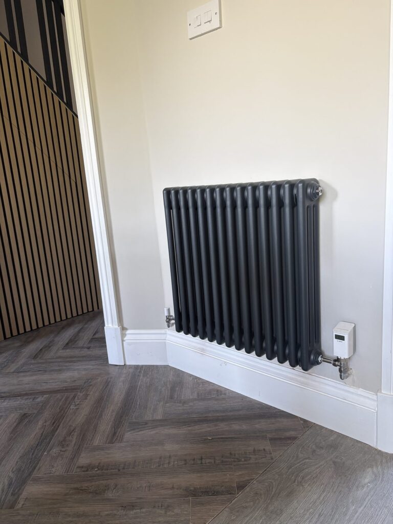 Horizontal anthracite column radiator with a smart thermostatic radiator valve installed