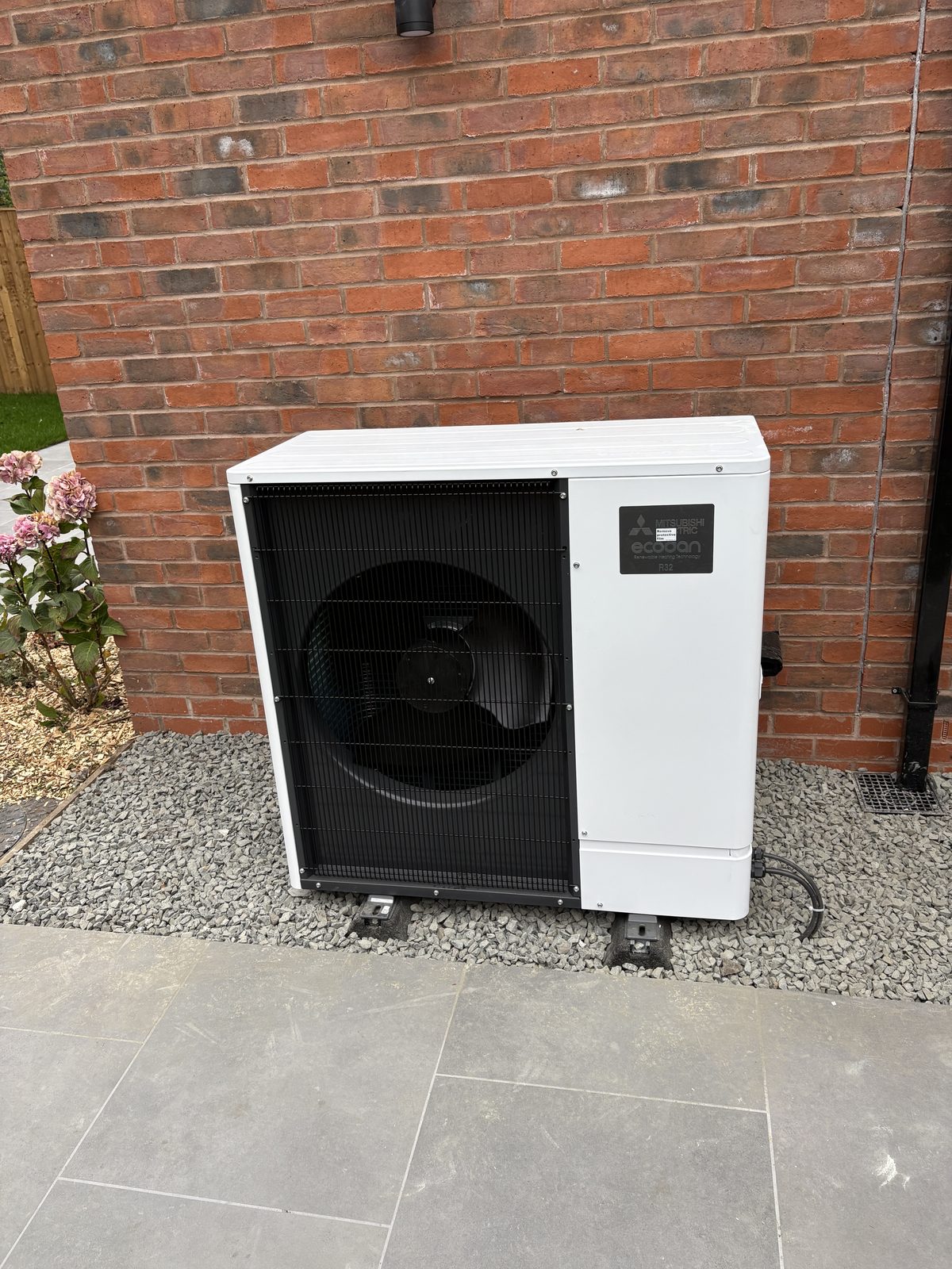 Mitsubishi Ecodan air source heat pump installed against a brick wall