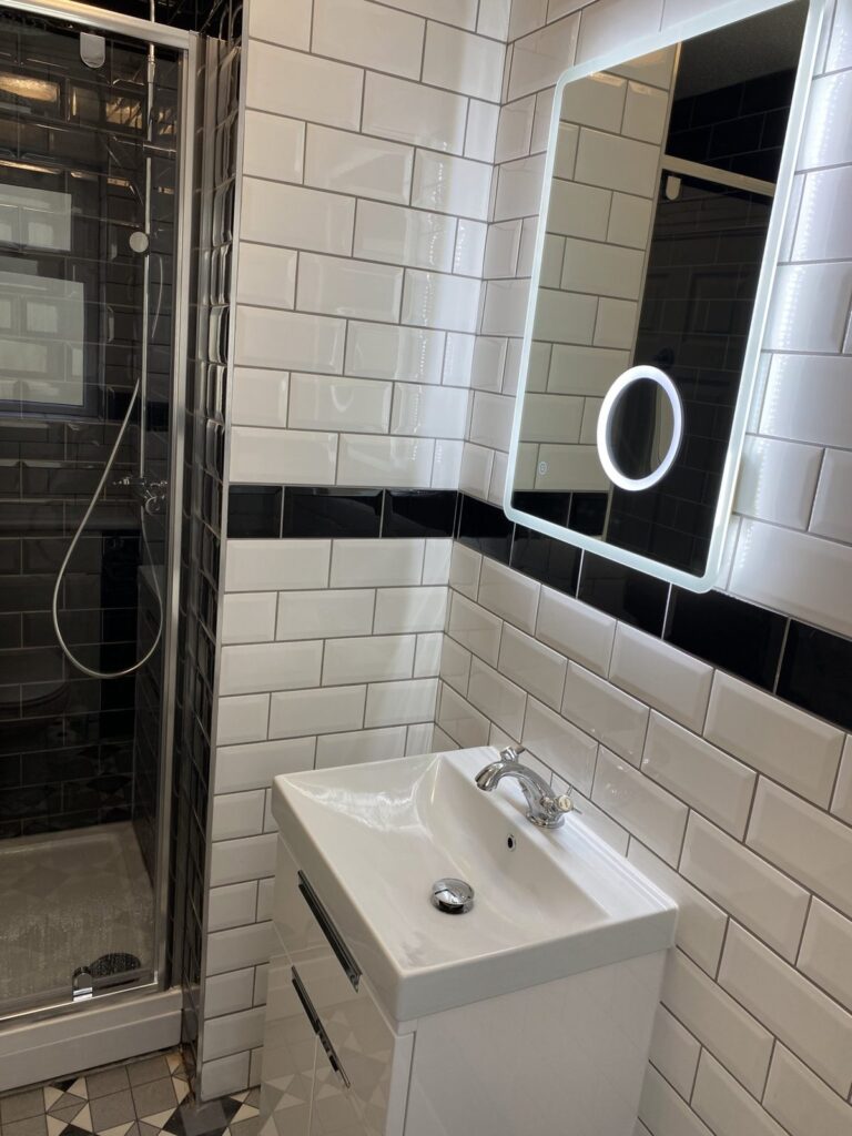Monochrome bathroom with vanity unit and shower, installed by CMG