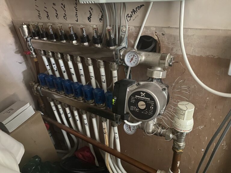 Underfloor heating manifold with labelled circuits, flow meters and circulation pump