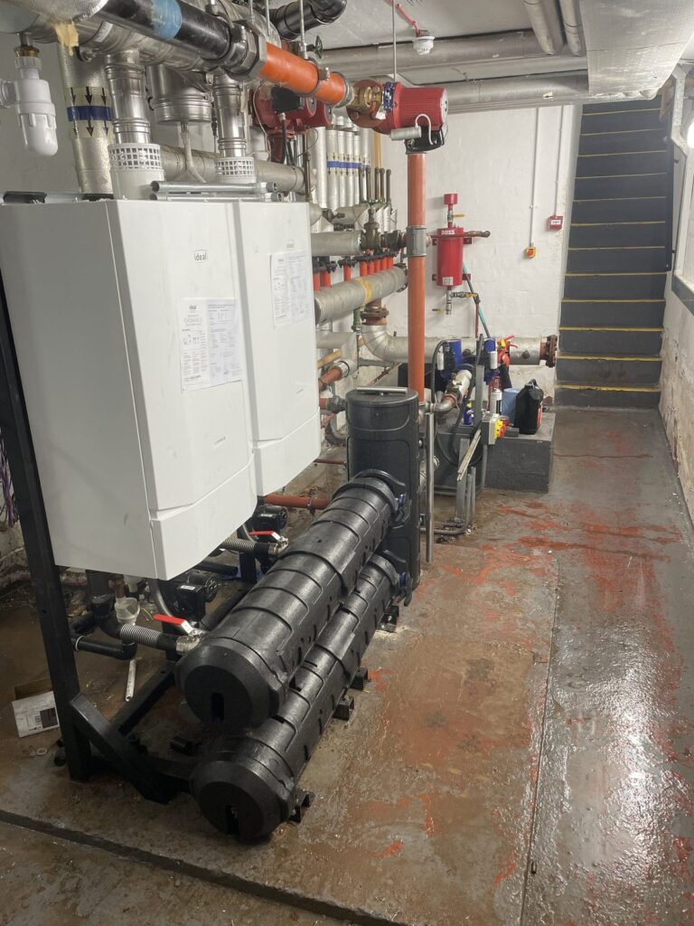 Commercial plant room with twin Ideal Evomax 2 boilers, low loss header and pumps, installed by CMG Heating & Plumbing