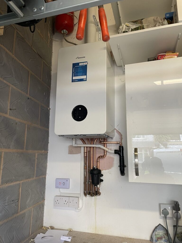 Worcester Bosch boiler installed in a utility room with magnetic system filter and heating control, by CMG Heating & Plumbing
